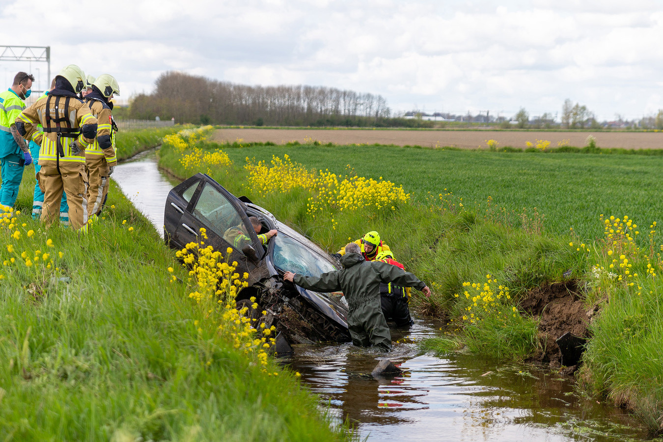Hulpdiensten massaal uitgerukt voor auto in sloot in Terheijden Foto