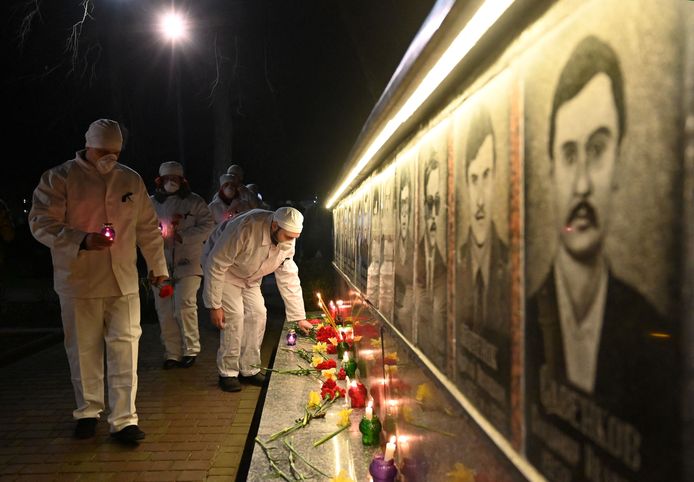 Oud-werknemers van de kerncentrale leggen in Slavoetytsj bloemen en kaarsen neer bij het monument voor de omgekomen brandweermannen.