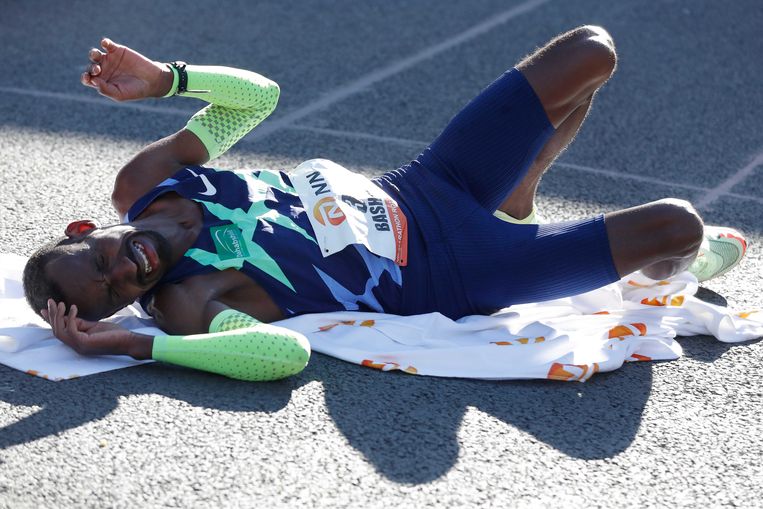 Bashir Abdi valt uitgeput op de grond na de marathon in Rotterdam. Beeld ANP