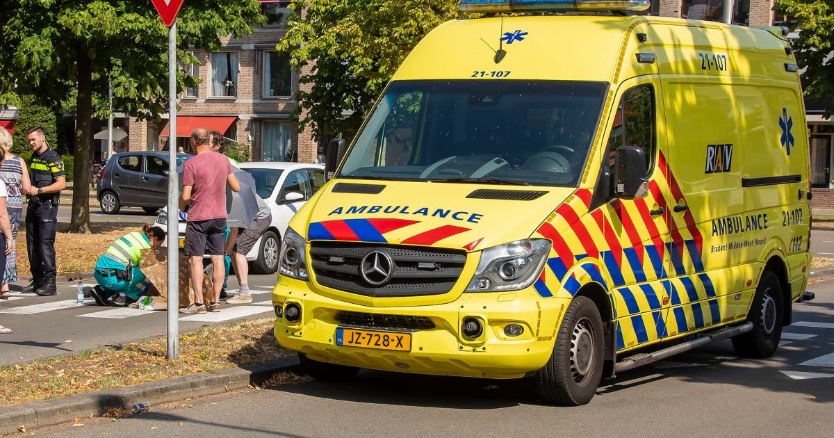 Omstanders houden gewonde fietser uit de zon met paraplus na aanrijding in Oss.