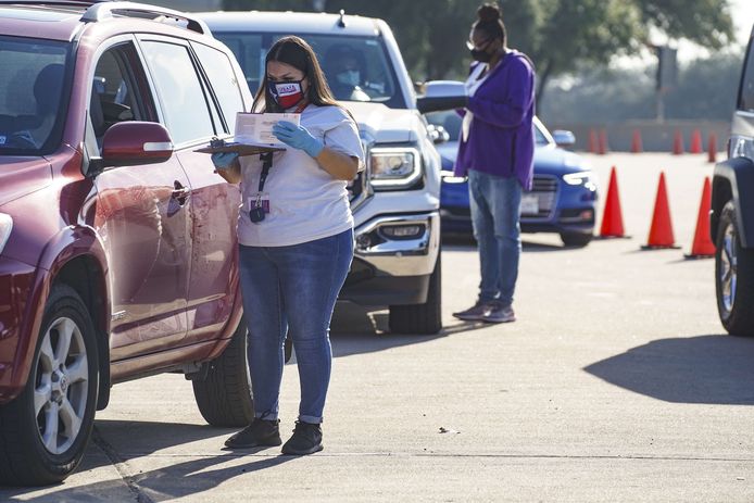 Verkiezingsmedewerkers nemen de stembiljetten in ontvangst bij een drive-through stemlokaal in Houston, Texas. (07/10/2020)