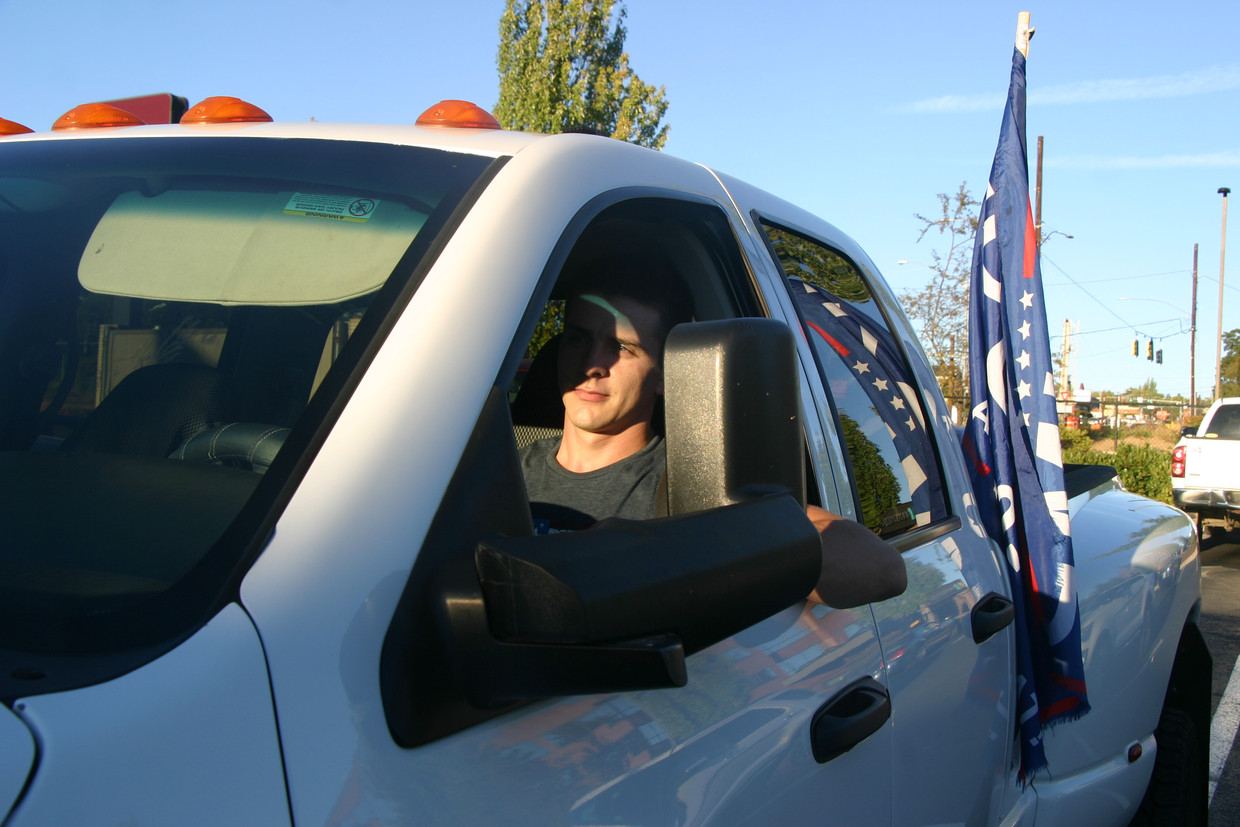 Val Andrychuk rijdt met zijn Trump-vlag door de voorstad Clackamas. ­ Beeld Michael Persson