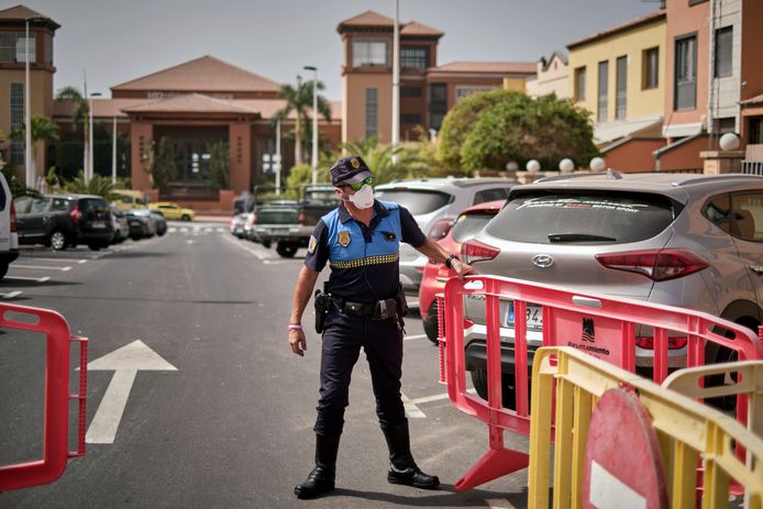 Een Spaanse politieagent sluit de toegang tot het H10 Costa Adeje Palace hotel op Tenerife af.