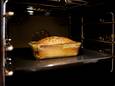 View into oven with finished cake in glass loaf pan sitting on shelf.