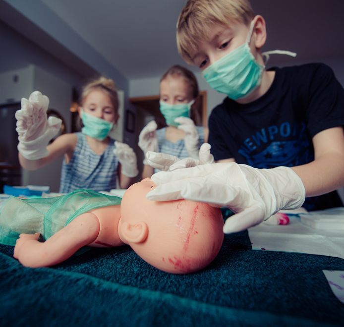Kinderen oefenen EHBO op een pop.