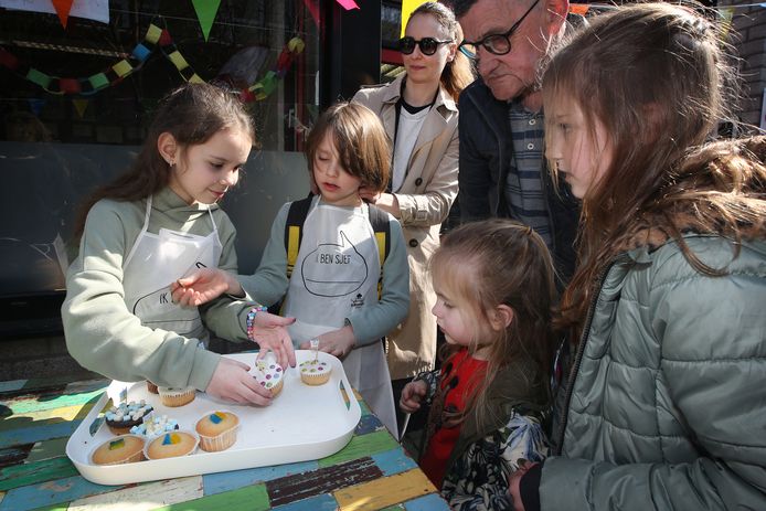 Polina en haar neefje Rodian verkopen versierde cakejes bij Den Bijstere. Tante Oksana Karpova (derde van links) kijkt toe.