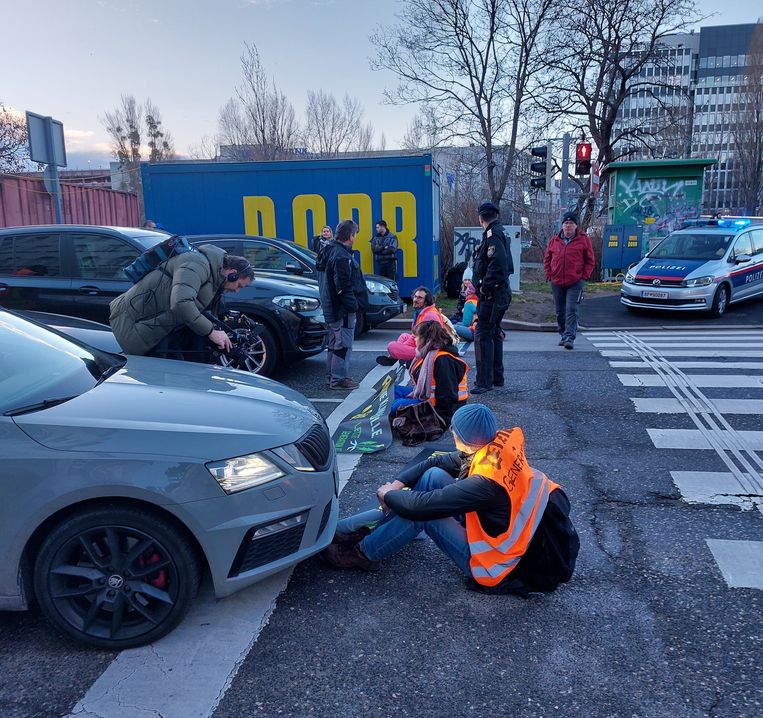 Klimaatactivisten lijmen zich vast aan een drukke weg in het noorden van Wenen. Beeld Anne ter Rele