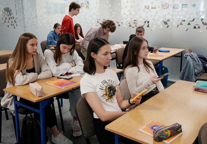 Studenten zitten op hun smartphone tijdens de les.