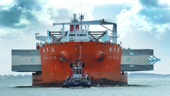 Het transportschip is uitgekiend geladen: de ene kant steekt acht meter voorbij het 42 meter brede schip, de andere dertien, maar het is precies in balans.