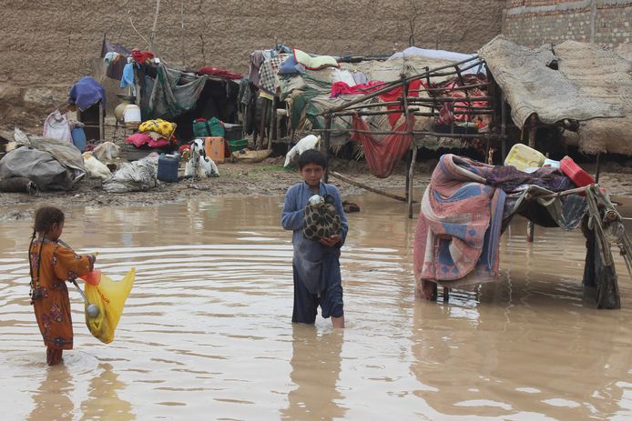 Kinderen zoeken hun weg door het water in de zwaar getroffen provincie Quetta in Pakistan.