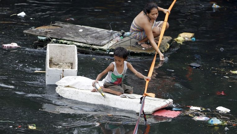 Inwoners van Manila slaan op de vlucht na zware regenval. Beeld EPA