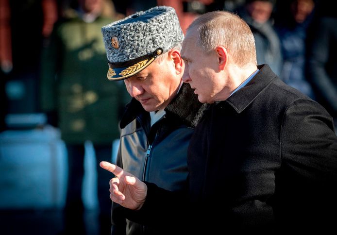 De Russische president Vladimir Poetin (rechts) spreekt met defensieminister Sergei Shoigu.
