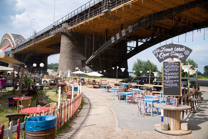 Zomerterras Opoe Sientje aan de Waal. Met tussen de tafeltjes het voetpad naar de strandjes.