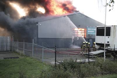 Flinke knallen en grote rookwolken bij uitslaande brand in hal van handelaar in fietsaccu’s
