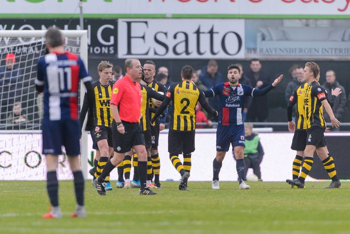 Spelers van beide ploegen omringen scheidsrechter Wim Bronsvoort.