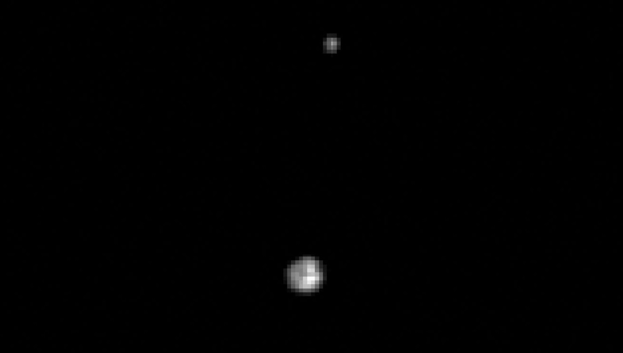 Pluto en de maan Charon, in 1997 gezien door de Hubble-telescoop. Beeld NASA