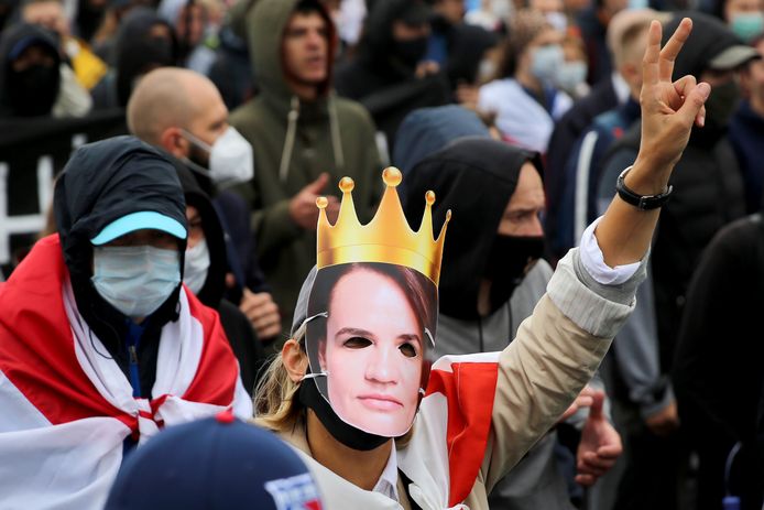 Een protestant draagt een masker van oppositieleidster Svetlana Tichanovskaja.