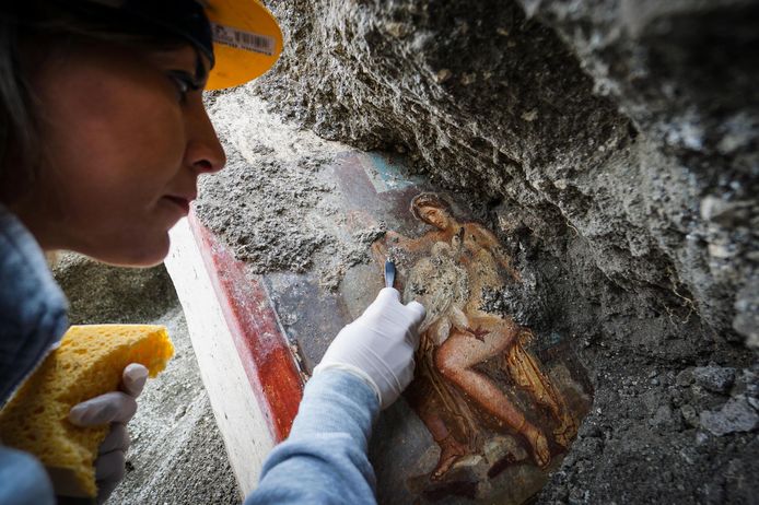 Een archeoloog werkt aan het nieuw ontdekte fresco Leda en de zwaan, in Pompeii.