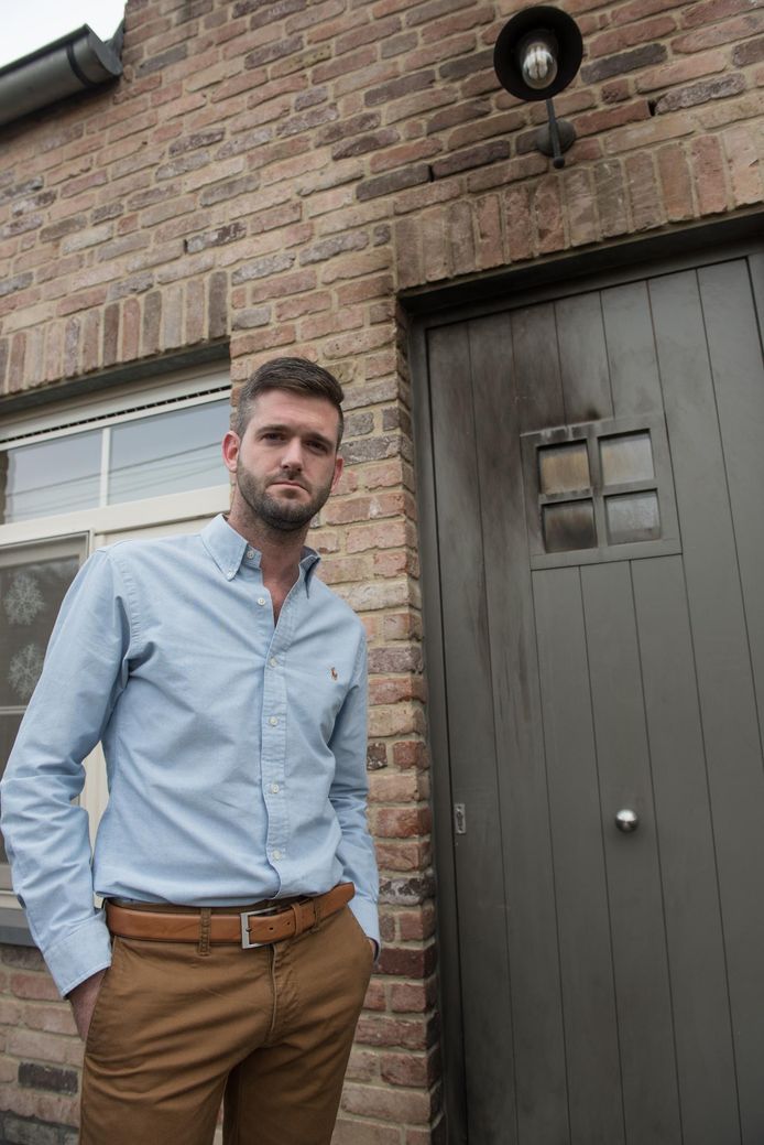 Kapper Diego Mahieur bij zijn zwartgeblakerde voordeur en -gevel.