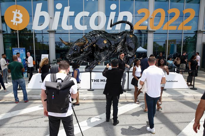 Bezoekers van de Bitcoin Beurs 2022, het grootste bitcoin evenement ter wereld, poseren begin vorige maand in het Miami Beach Convention Center bij de Miami Bull nabij de ingang van het beursgebouw. Foto Getty Images