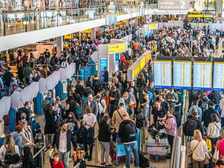 Brandweer deelt water uit aan wachtende mensen op druk Schiphol