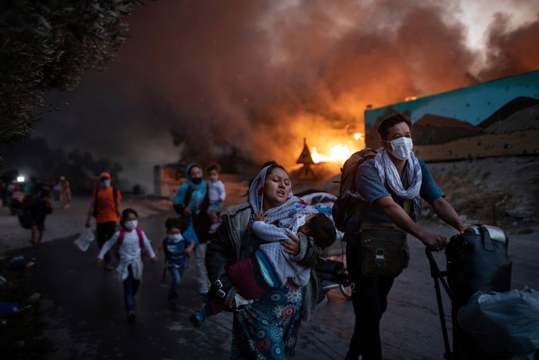 Migranten vluchten weg uit het vluchtelingenkamp Moria op Lesbos, nadat daar voor de tweede keer in twee dagen brand is uitgebroken. Archiefbeeld van september vorig jaar. Beeld AP