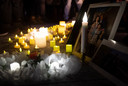 Brandende kaarsen voor een portret van slachtoffers van de vliegramp in Iran.