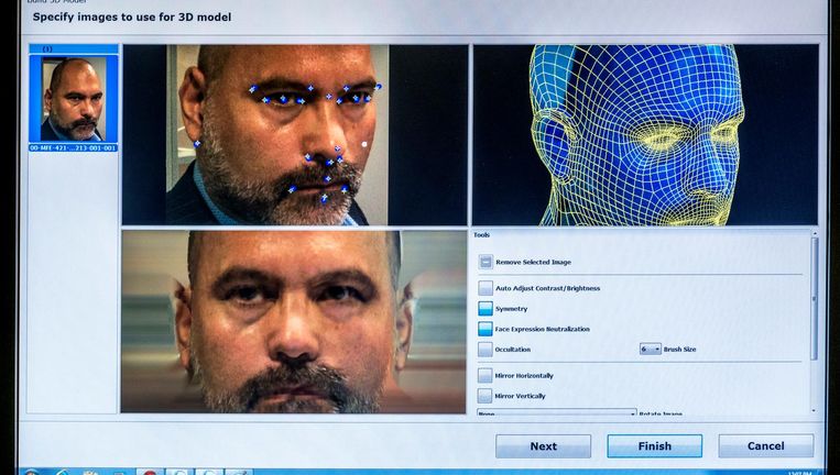 De computer toont op basis van gezichtskenmerken uit een foto een mogelijke match uit de database. Deskundigen beoordelen de suggestie. Beeld Raymond Rutting