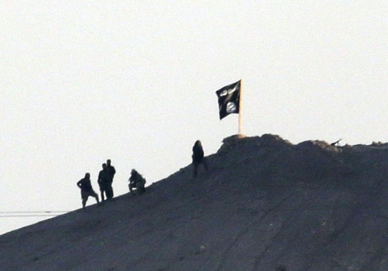 In de strijd om de Noord-Syrische stad Kobane, bij de Turkse grens, heeft Islamitische Staat zijn zwarte vlag gehesen op een strategische berg nabij de stad. Beeld AP