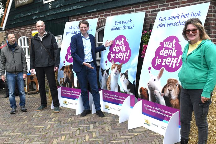 Wethouder Barker poseert naast de posters die op verschillende plekken komen te hangen.