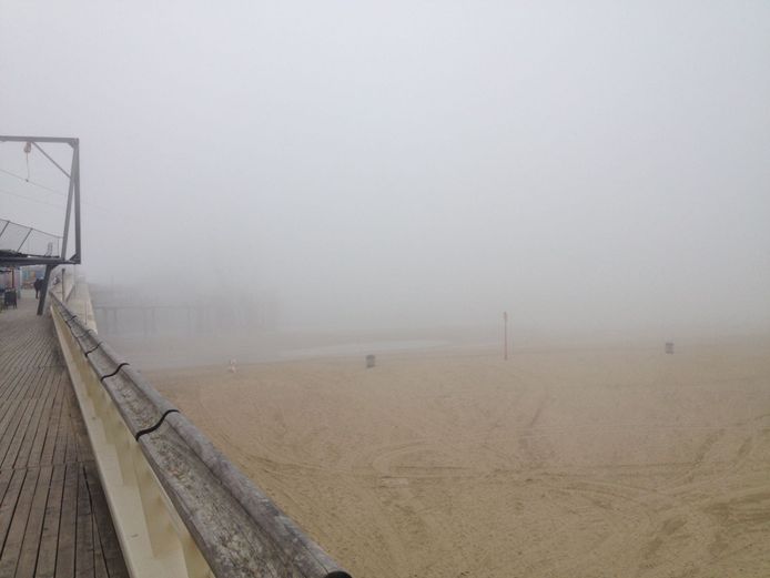 Op de pier van Scheveningen is het een grauwe boel. De zee is nauwelijks zichtbaar.