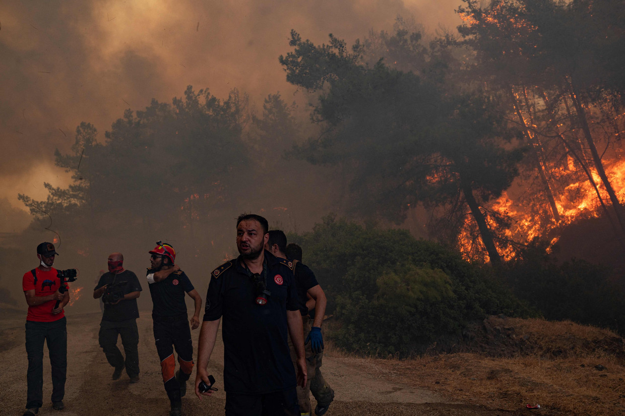 Brandweerlieden tussen de bosbranden bij het Turkse Marmaris. Beeld AFP