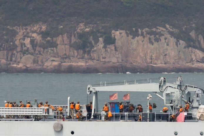 Soldaten staan op het dek van een Chinees oorlogsschip terwijl het vaart tijdens een militaire oefening.