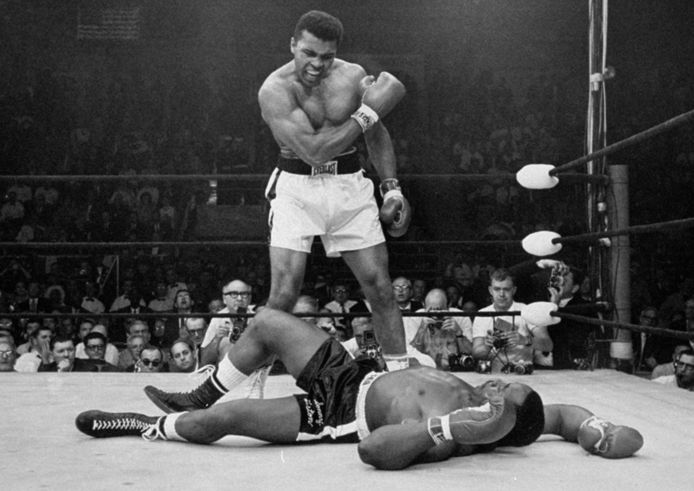 Op deze foto die op 25 mei 1965 genomen werd, staat Muhammad Ali over zijn gevallen uitdager Sonny Liston in Lewiston, Maine.