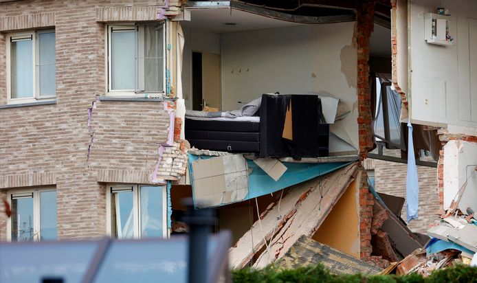 One hangs from a damaged apartment.  A heavy gas explosion in Turnhout destroyed an apartment complex.  (AP Photo/Olivier Matthys)