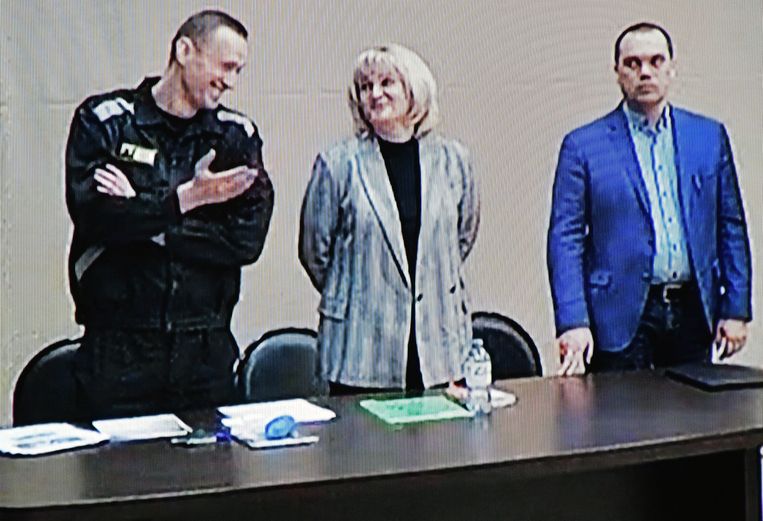 Een lachende Navalny overlegt met zijn advocaten op een rechtbankzitting in Strafkolonie nr. 2, vorige maand. Beeld Photo News
