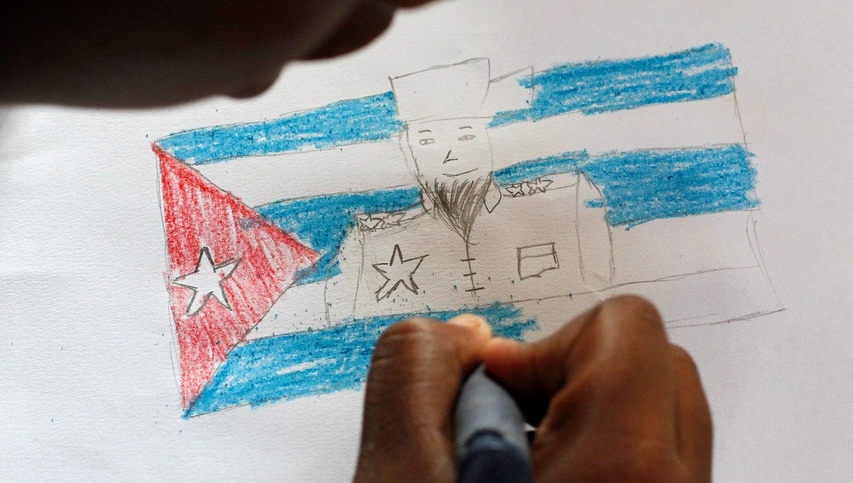 Een Cubaans meisje tekent Fidel Castro op de nationale vlag, ter ere van de verjaardag van de gewezen leider. Beeld REUTERS