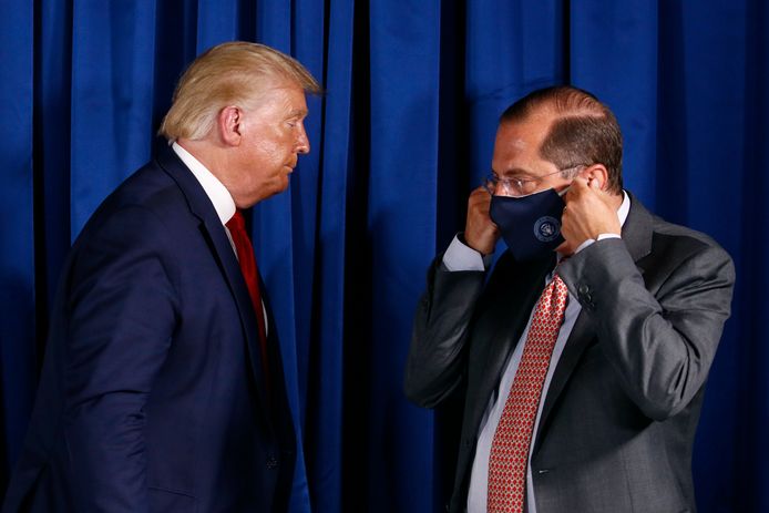 De Amerikaanse minister van Gezondheid Alex Azar (rechts met mondkapje) met president Donald Trump.