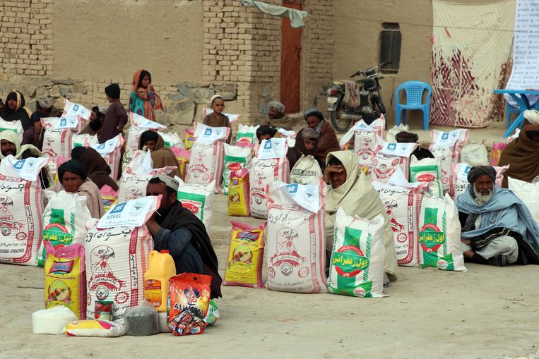Afghanen in de stad Kandahar krijgen een rantsoen uitgedeeld. Mede door de westerse sancties is de voedselsituatie in Afghanistan uiterst onzeker geworden. Beeld EPA
