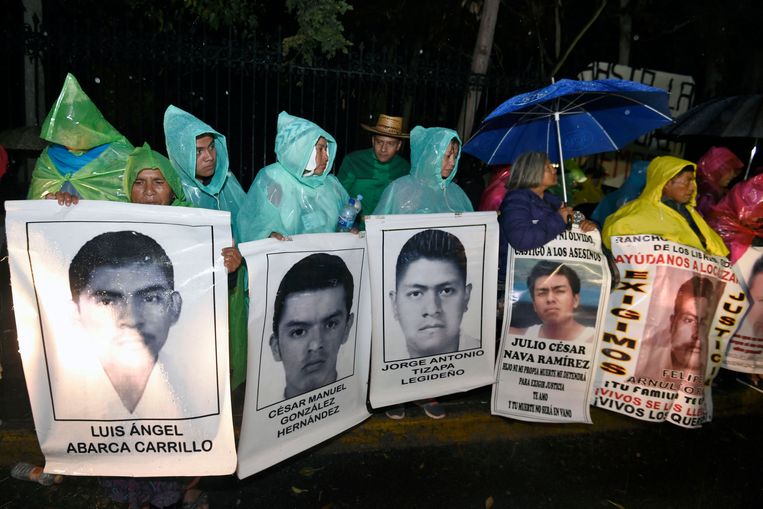 Familie en vrienden van de 43 verdwenen studenten demonstreren op kerstavond 2014 met grote foto's van de vermisten voor het toenmalig presidentieel paleis Los Pinos in Mexcio-Stad. Beeld AFP