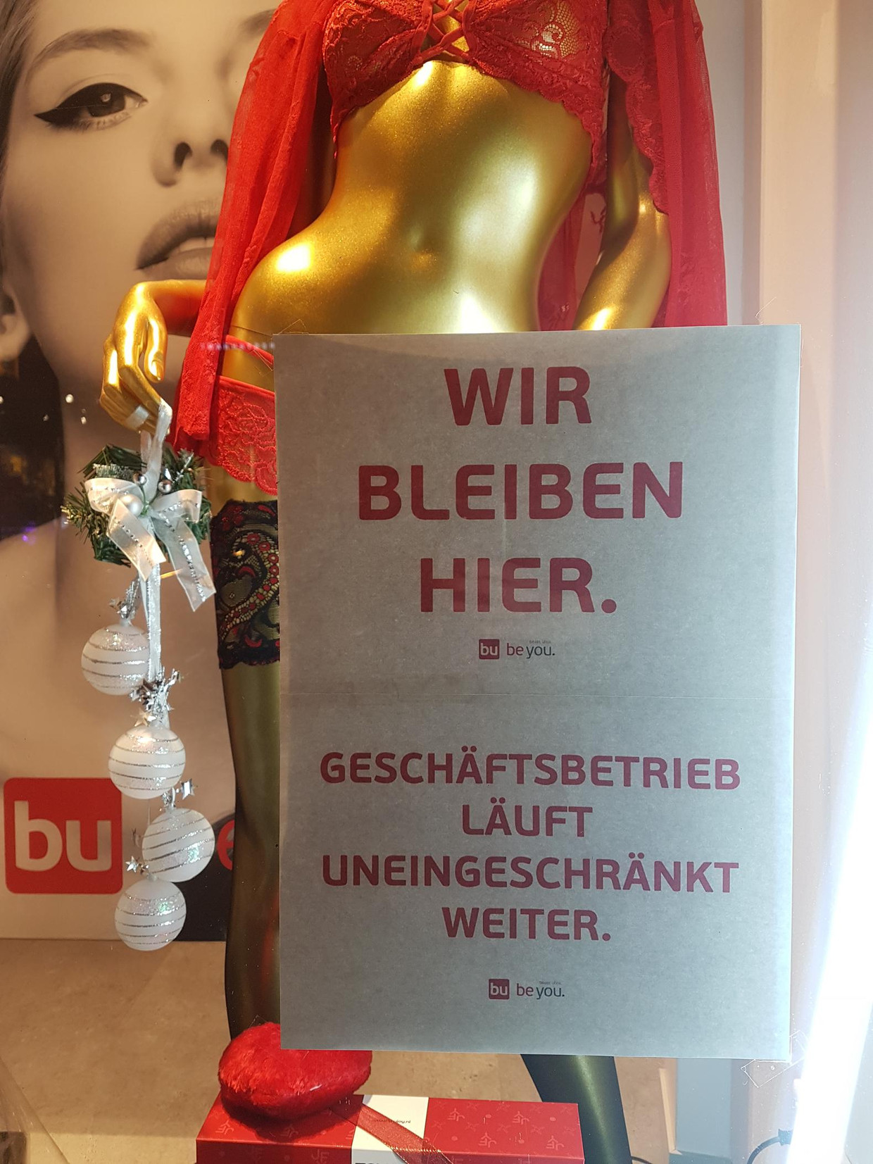 'We blijven hier' staat op het raam van het Berlijnse filiaal. Beeld   