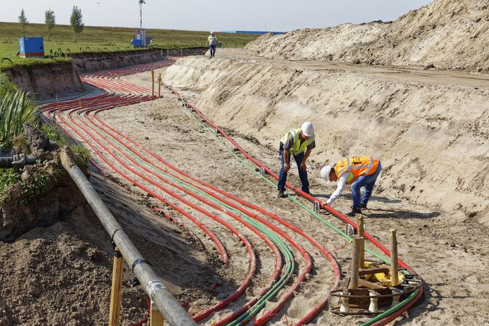 Medewerkers van Enexis en aannemers zijn aan de slag in een 8 meter brede gleuf aan de Overstortweg.