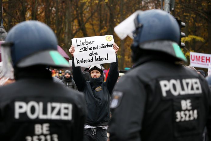 ArchiefbeeldEen demonstrant houdt een bord omhoog met daarop de slogan 'Liever staand sterven dan knielend leven' tijdens een protest tegen de coronamaatregelen in Berlijn november 2020.