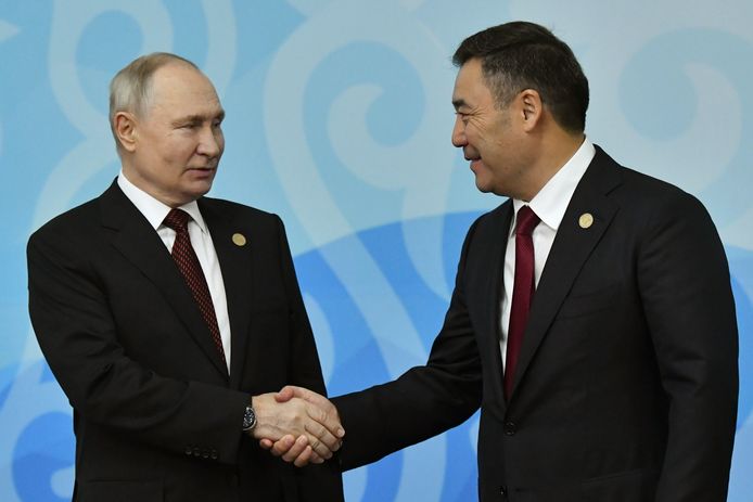 Vladimir Poetin (links) en de president van Kirgizië Sadyr Japarov (rechts) schudden elkaar de hand op de internationale top.