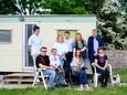 Irena Chepilko (4e van links) met haar familie voor de caravan op het terrein van de boerencamping van Linda (met groen vest) en Jan van de Wekken in Kerkwerve