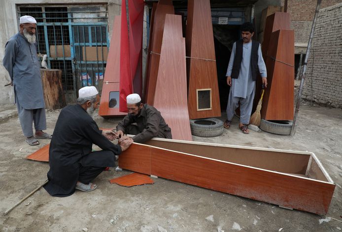 Afghaanse timmermannen maken doodskisten om te verkopen in hun winkel.