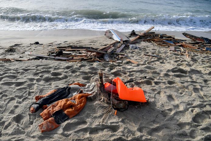 Een jas, een reddingsvest en stukken van de gezonken houten vissersboot op een strand in Steccato di Cutro.
