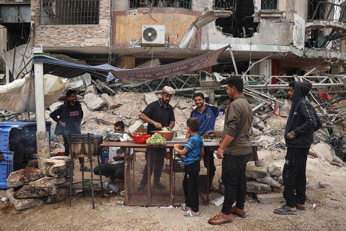 Een Palestijnse verkoper bereidt zich voor op het maken van sandwiches met falafel in een geïmproviseerd kraampje naast het bouwpuin in Khan Yunis in de zuidelijke Gazastrook (2/5/2024)