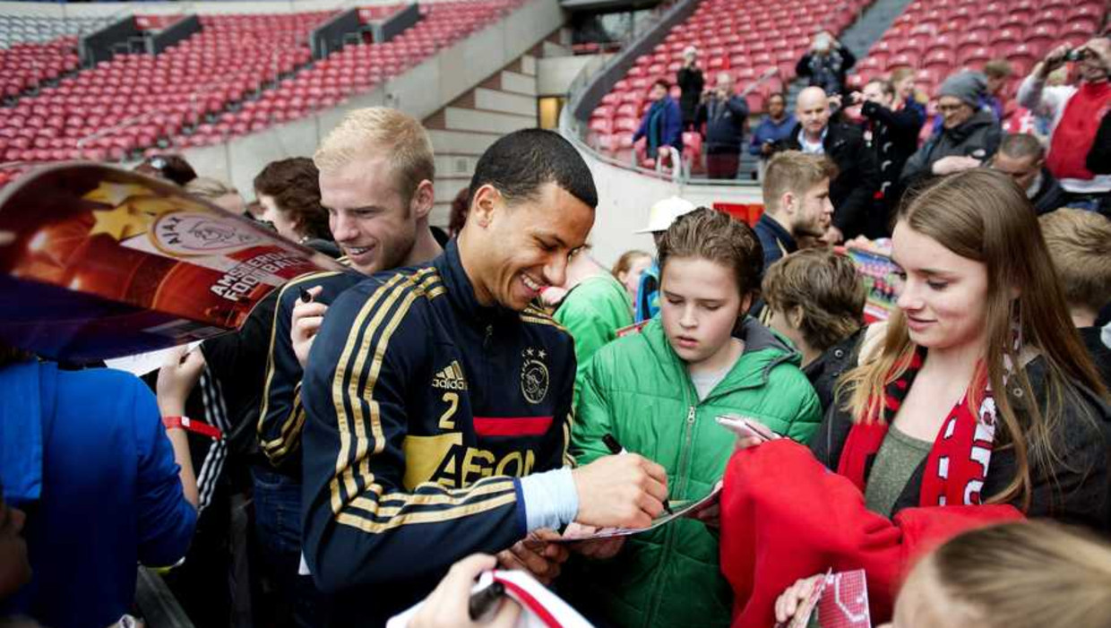 Ajax-spelers Ricardo van Rhijn (M) en Davy Klaasen delen handtekeningen uit aan jonge supporters. In de ArenA genieten duizenden supporters van het bijwonen van een training en een meet and greet met hun helden tijdens het jaarlijks Ajax-fanweekend. Beeld anp