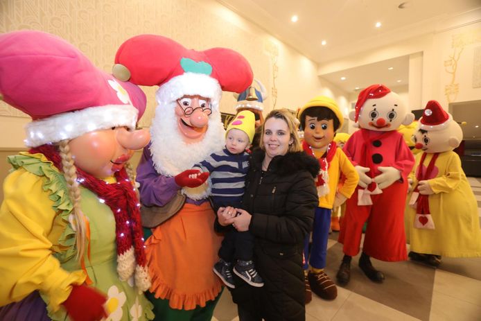 Terwijl hij bij mama Cindy op de arm zit, geeft Liam Kabouter Plop een handje. Ook de andere Plopsa-figuren staan al kaar.